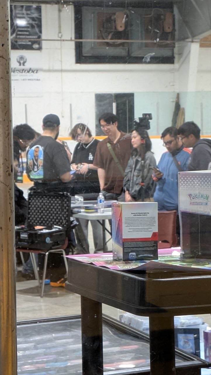 Pokémon card collectors examining rare cards at Hobbycon Winnipeg